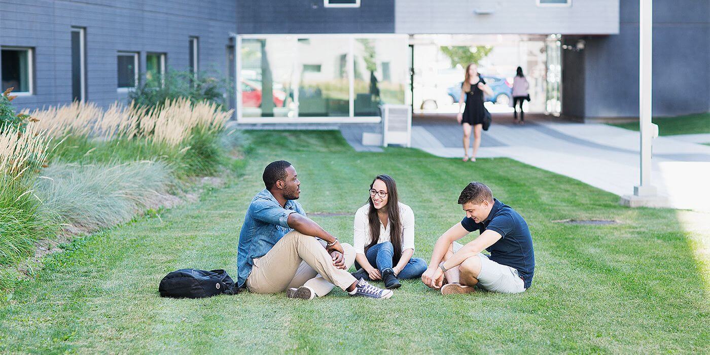 Étudiants détendus sur le campus verdoyant.