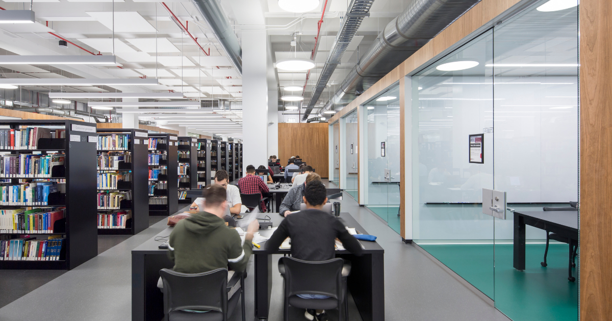 Un espace d'étude moderne, avec des tables et des étagères remplies de livres, favorisant la concentration et la collaboration entre étudiants.