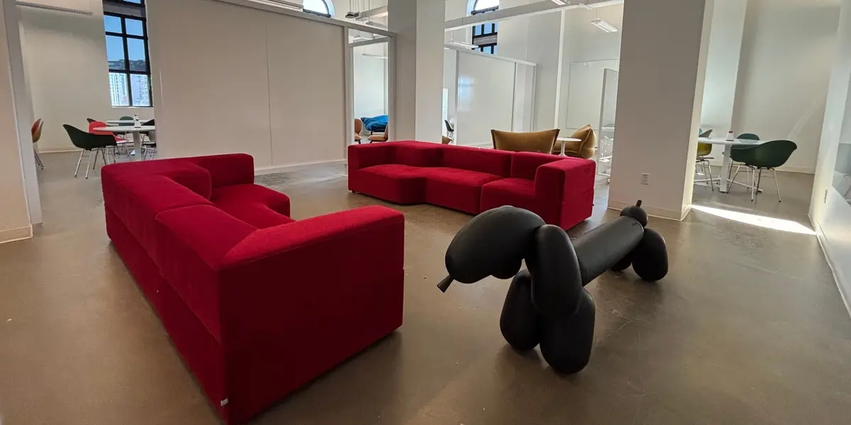 Lounge and collaboration area at INGO, within the KÉTS Institute’s premises. Large red sofas sit alongside a black dog-shaped sculpture in an airy space with high ceilings.