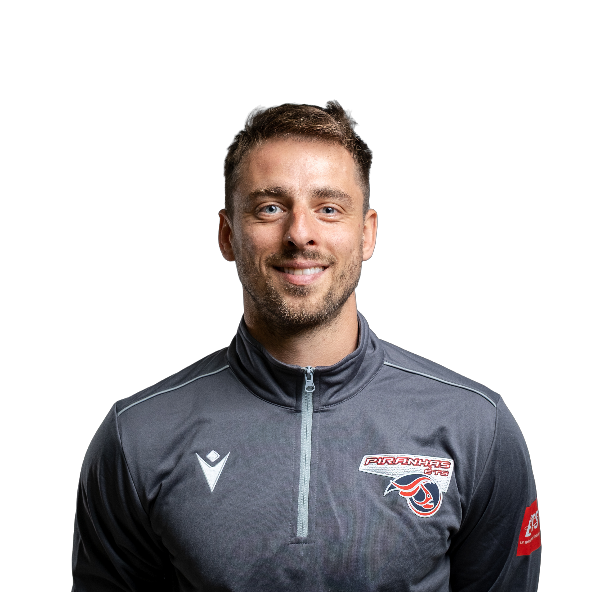 Un homme souriant porte un chandail de sport gris avec le logo des Piranhas, dégageant une ambiance chaleureuse et professionnelle.