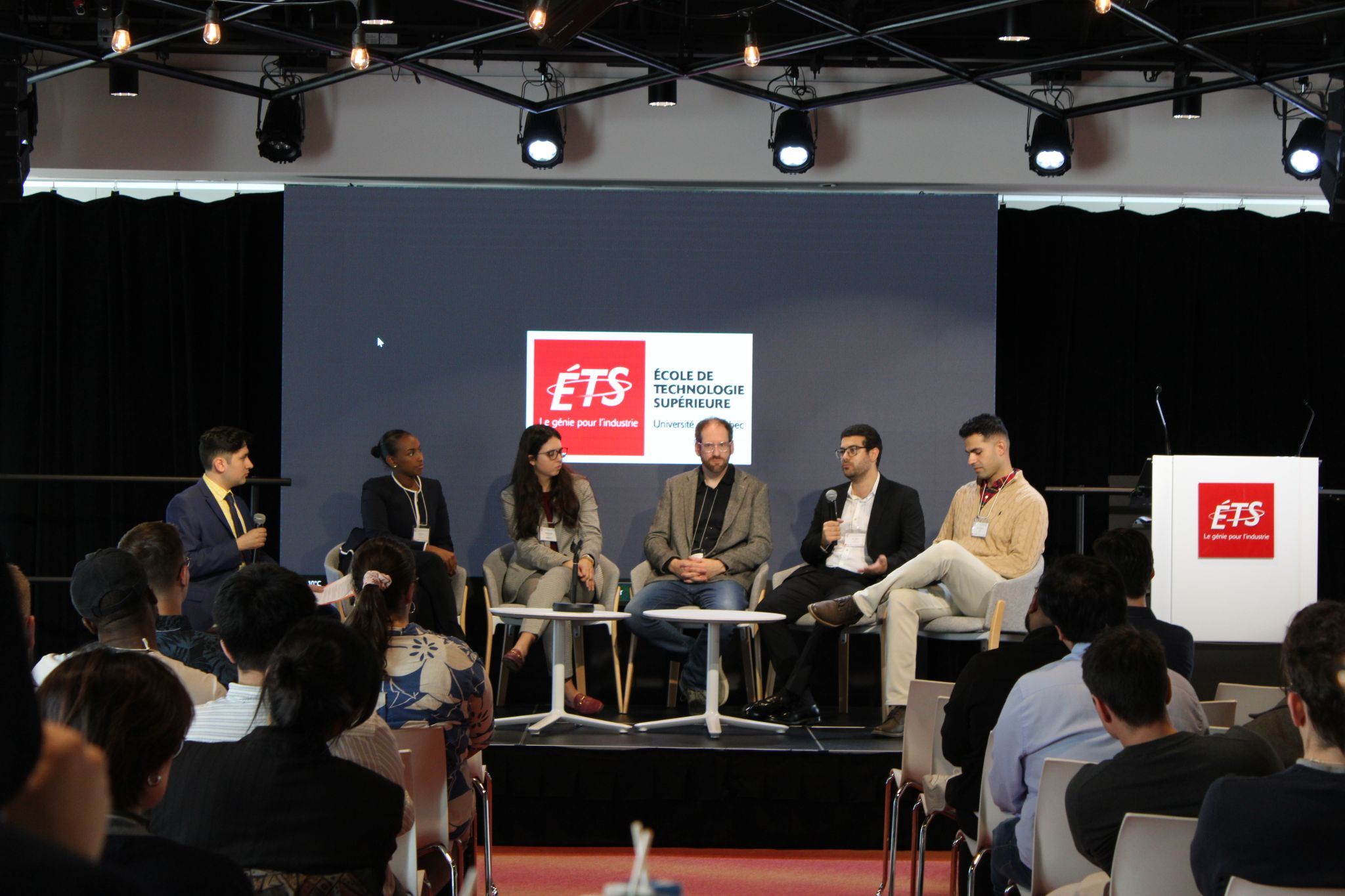 Discussion interactive sur les enjeux technologiques, réunissant des experts autour d'une table, dans un cadre moderne et dynamique.