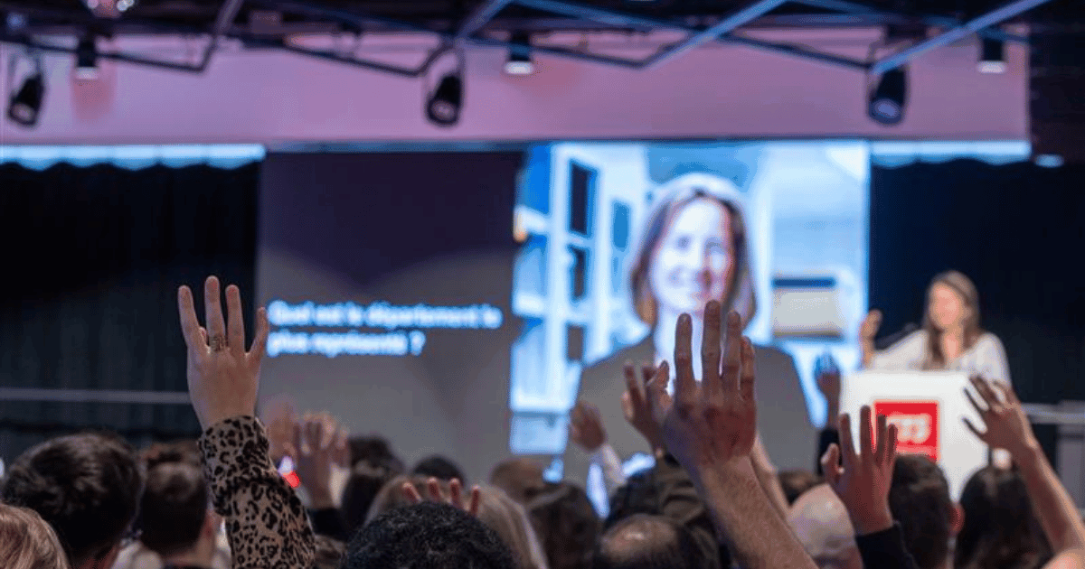 Un public engage avec des questions lors d'un événement académique à l’Université, favorisant l'interaction et l'apprentissage.