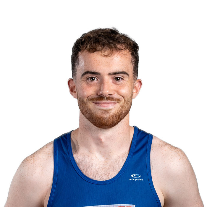 Un étudiant souriant en maillot de sport bleu, prêt à participer à des activités physiques et représentant l'esprit d'équipe.