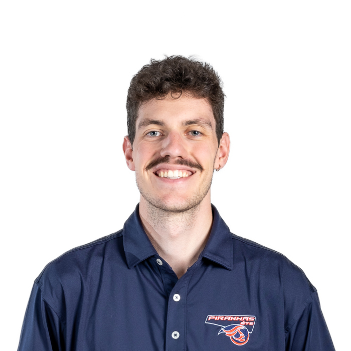 Étudiant en polo avec logo universitaire, moustachu, fond blanc uni.