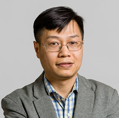 A professional in technology, wearing glasses and a gray blazer, exuding confidence and expertise in their field.