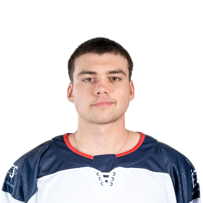 Joueur de hockey avec un regard déterminé, portant un maillot aux couleurs de l'institution, symbolisant l'esprit d'équipe et la passion.