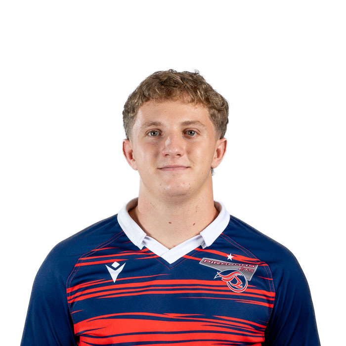 Étudiant en technologie, il porte un maillot aux couleurs vives, affichant un sourire assuré et une attitude positive.