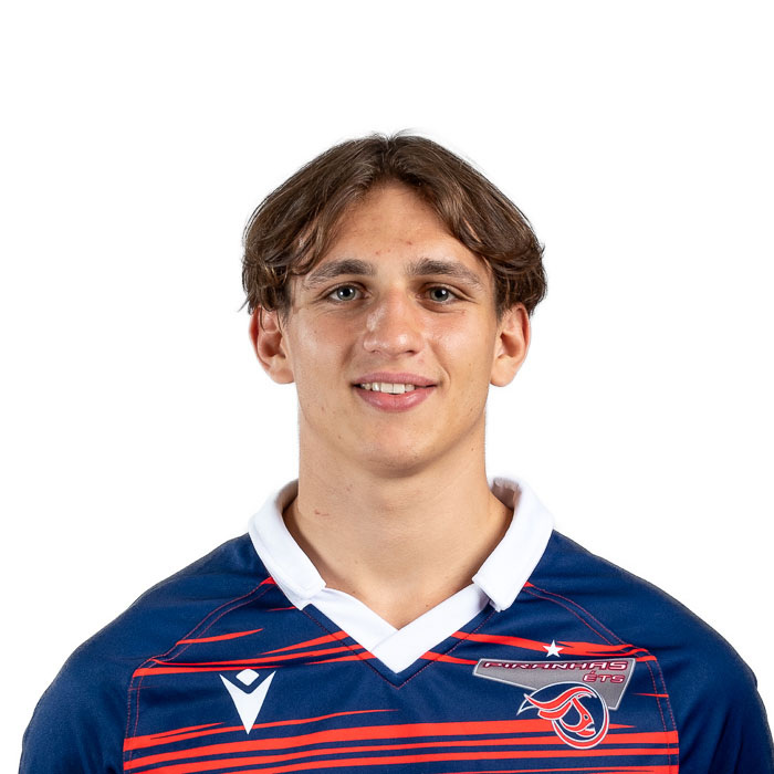 Étudiant passionné de technologie, il sourit en portant le maillot de son équipe, illustrant l'esprit sportif et communautaire de l'université.