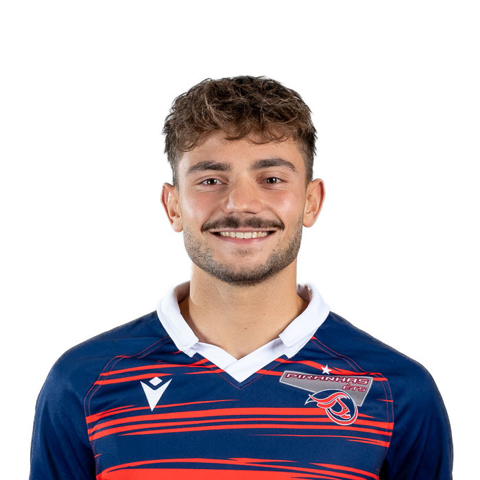 Jeune homme souriant, portant un maillot sportif aux couleurs vives, démontrant énergie et esprit d'équipe.