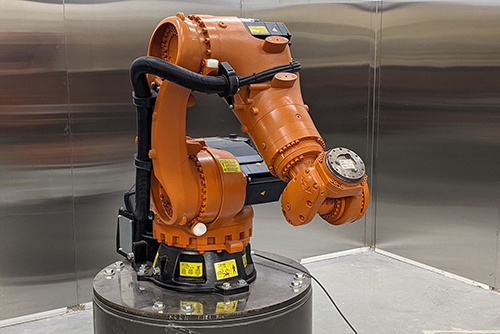 Robot industriel articulé pour l'automatisation des processus, intégré dans une salle de recherche.