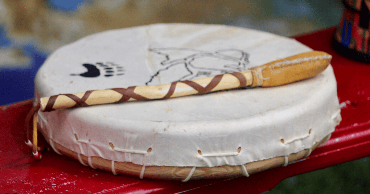 Un tambour traditionnel avec une baguette ornée, symbole de culture et d'artisanat, évoquant la musique et la spiritualité.