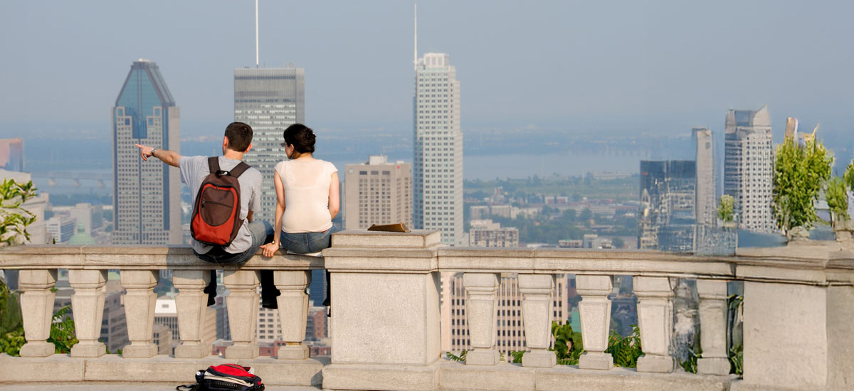 Deux étudiants profitent d'une vue panoramique sur la ville, échangeant des idées et contemplant le paysage urbain.
