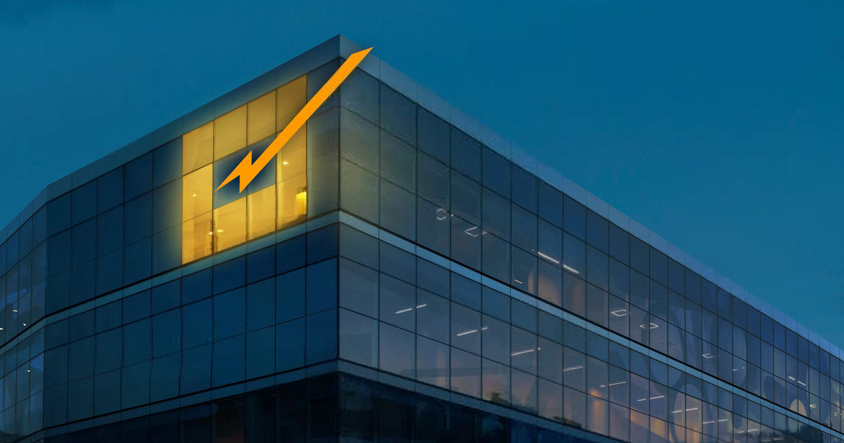 Bâtiment moderne avec une façade vitrée, illuminé au crépuscule, symbole d'innovation et de technologie. Ambiance dynamique et accueillante.