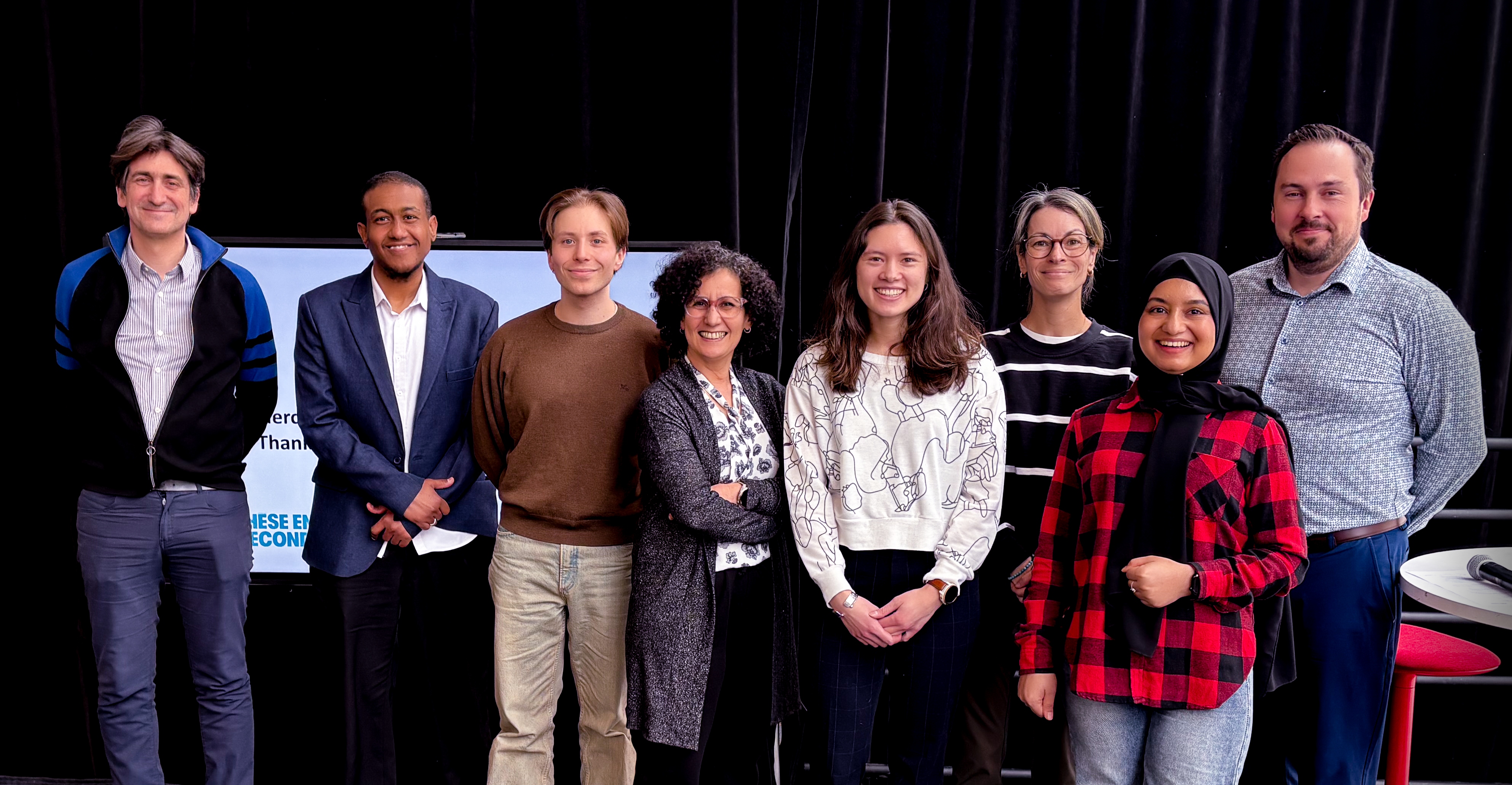 Équipe diversifiée et souriante, réunie pour partager des idées et célébrer des réalisations au sein de l'université.