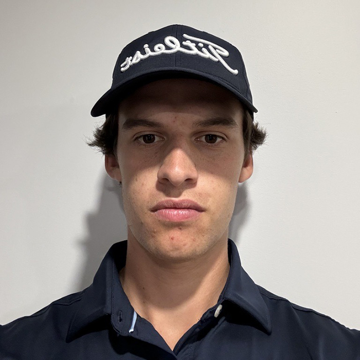 Jeune adulte sérieux portant une casquette sportive et un haut sombre.