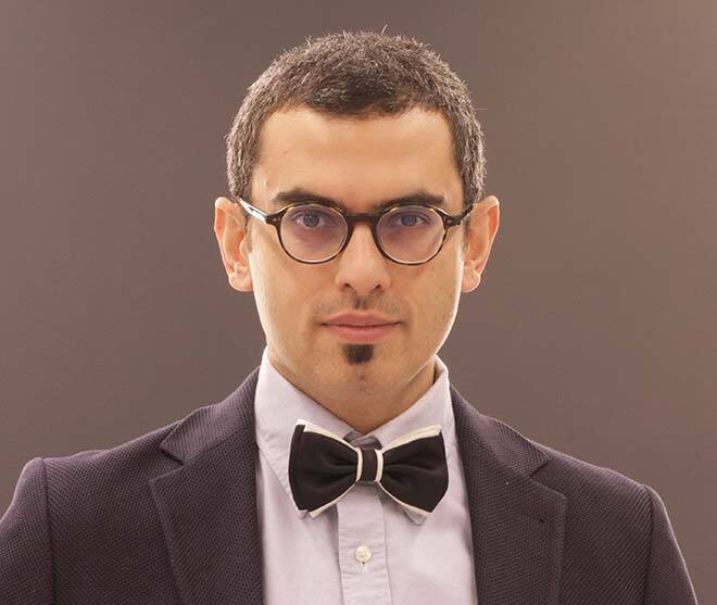 Confident academic in suit and bowtie, showcasing professionalism and intellect.