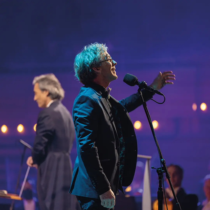 Un artiste s'exprime avec passion sur scène, captivant le public dans une ambiance festive et musicale.