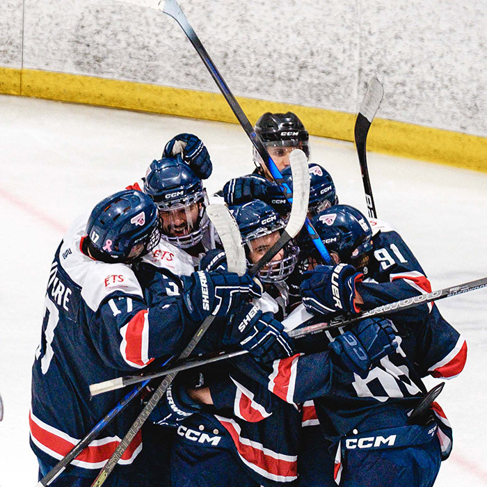 Célébration d'équipe sur la glace, des joueurs de hockey montrent leur joie après un but marqué. Esprit d'équipe et passion au rendez-vous.