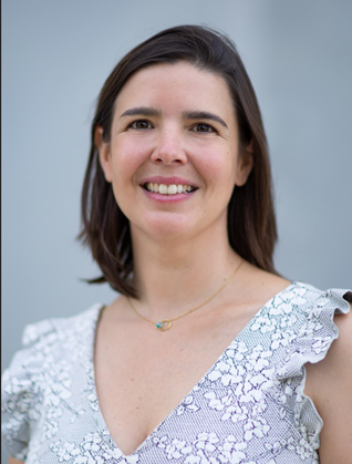 Professeure souriante, fond neutre, blouse à motifs, expertise en technologie.