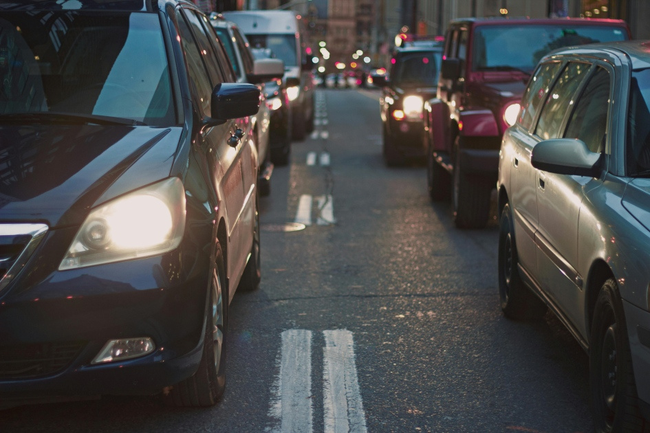 Circulation dense en milieu urbain, véhicules alignés dans une rue, créant un spectacle d'activités nocturnes.