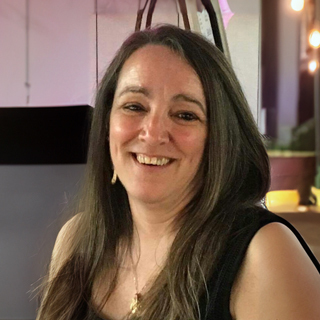 Une professionnelle souriante, mettant en avant son expertise et son engagement dans le domaine technologique. Ambiance conviviale et dynamique.