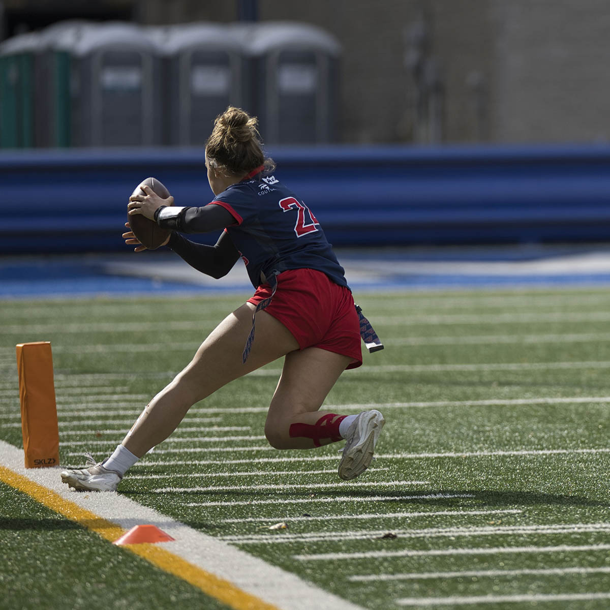 Une joueuse de football s'apprête à marquer un point près de la ligne de touche, illustrant l'énergie et la détermination du sport.