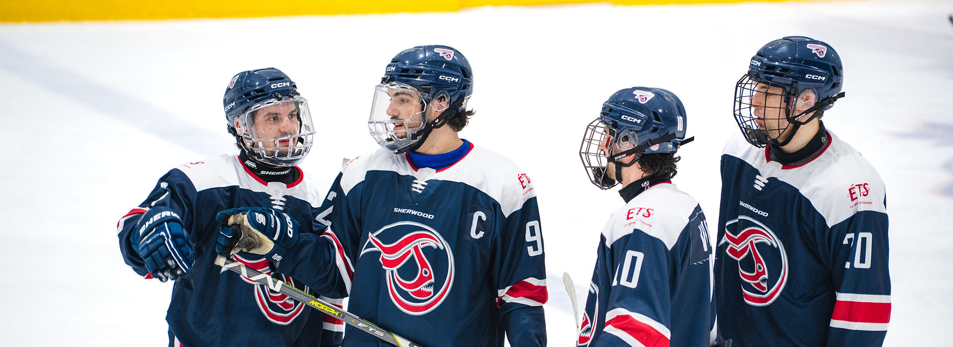 Team members strategize on the ice, showcasing teamwork and camaraderie in a competitive hockey environment.