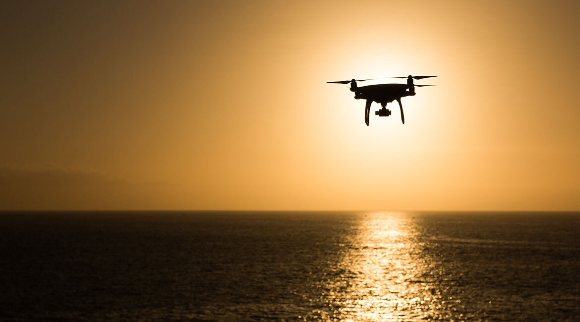 Drone en vol, coucher de soleil sur l'océan, technologie et innovation.