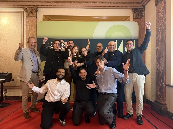 Des étudiants et enseignants, tous souriants, célèbrent un succès collectif lors d'un événement marquant à l'Université.