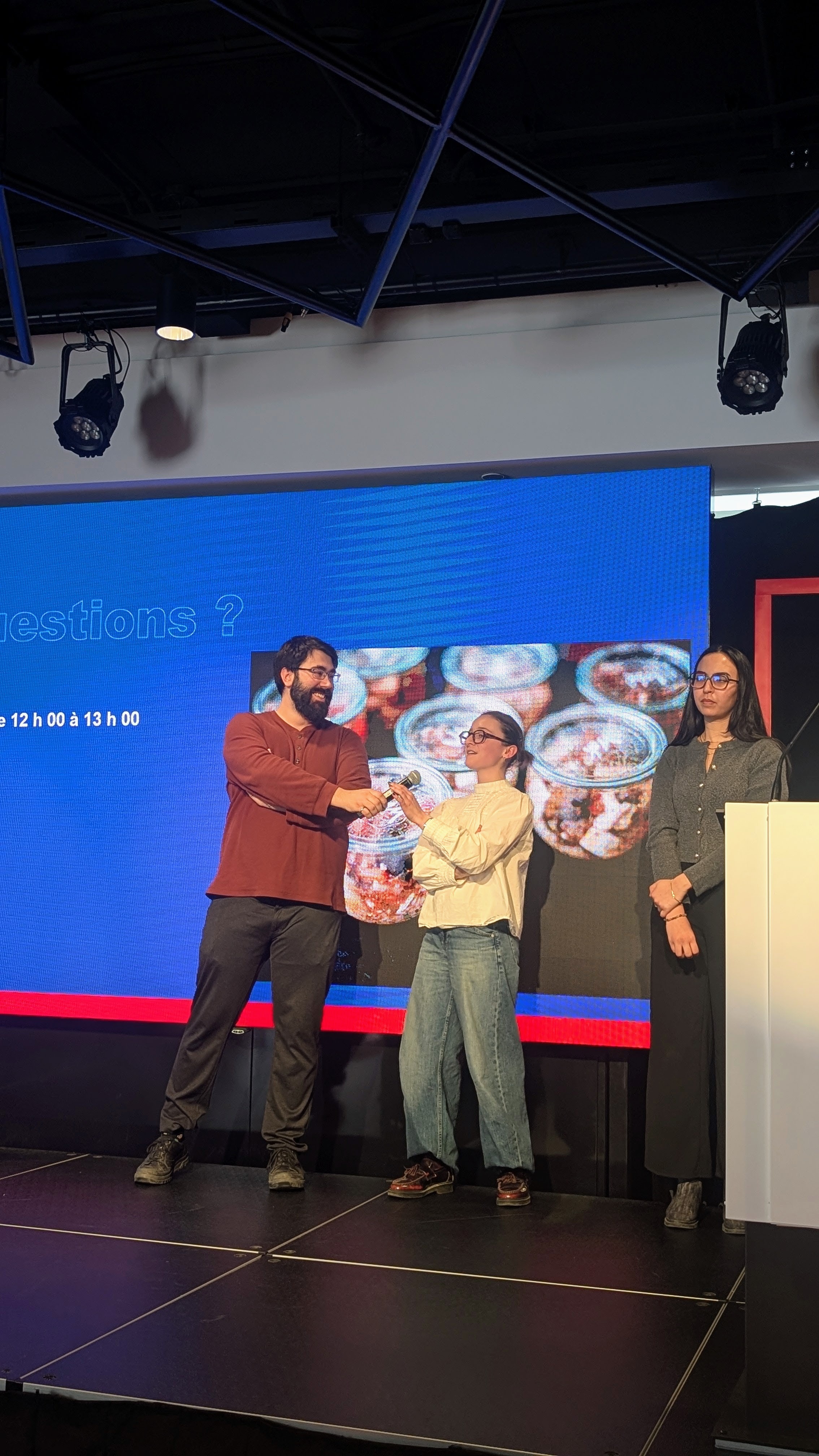 Présentation interactive avec des intervenants échangeant des idées, accompagnée d’une image captivante en arrière-plan.