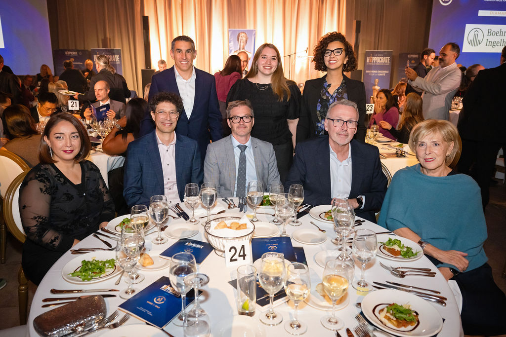Groupe de professionnels rassemblés autour d'une table lors d'un événement élégant, avec des plats raffinés et un décor soigné.