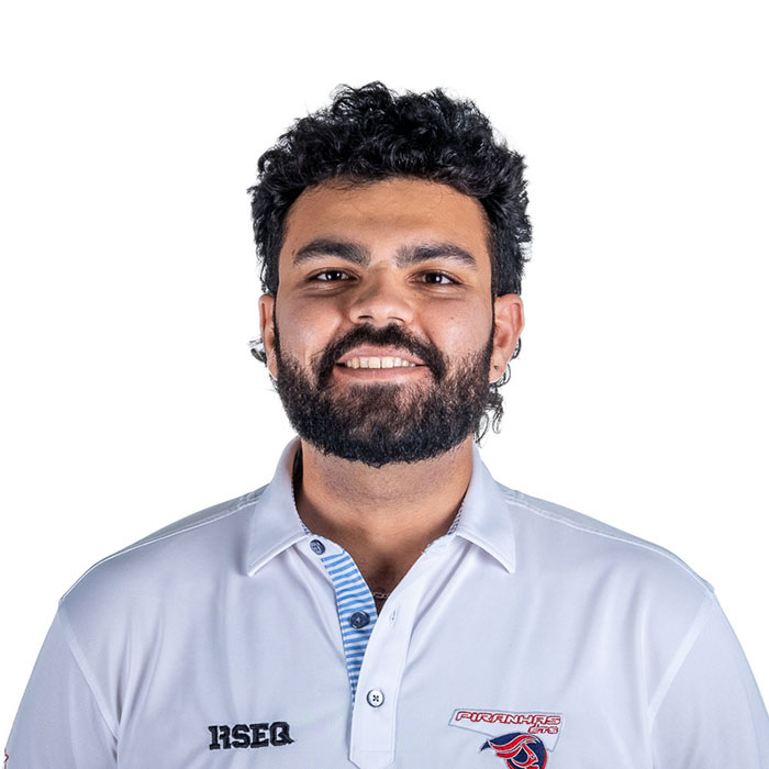 Étudiant souriant en chemise de l’Université, représentant l’esprit dynamique et engagé de la communauté technologique.