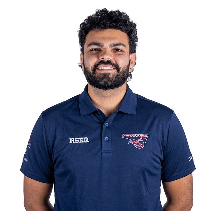 Étudiant souriant en chemise de l’Université, représentant l’esprit dynamique et engagé de la communauté technologique.