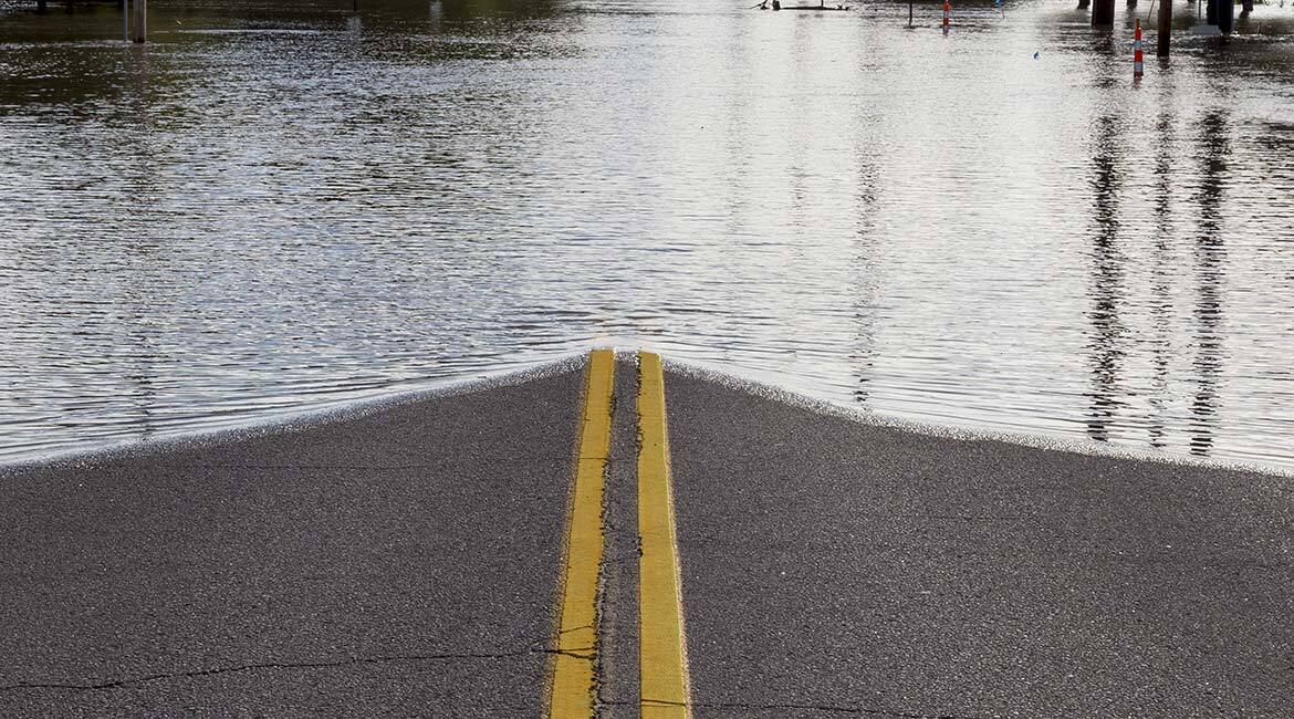 Route submergée par une inondation, illustrant l'impact des changements climatiques.