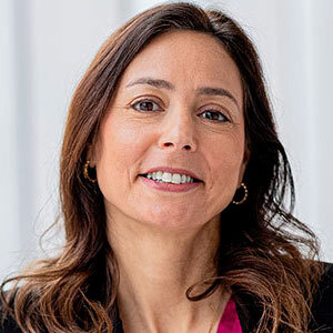 Portrait d'une professionnelle souriante, affichant un air accueillant et confiant, idéal pour représenter un environnement universitaire.