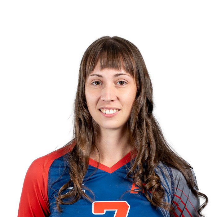 Étudiante souriante en maillot de sport avec logo universitaire. Représente la diversité et l'engagement étudiant.