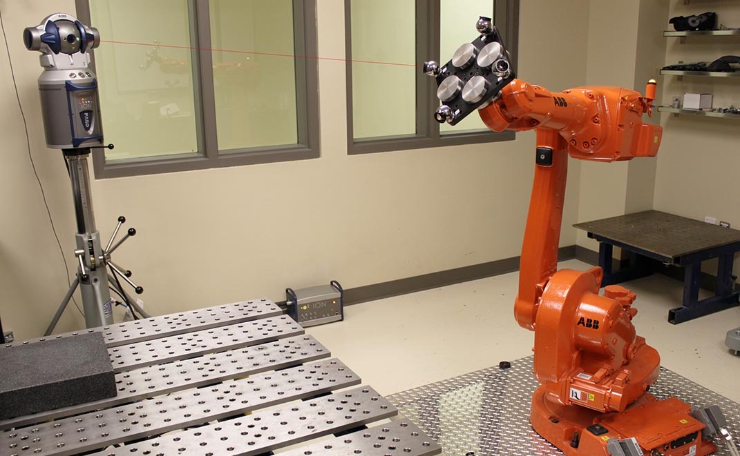 Laboratoire avec robot industriel ABB et système de mesure par laser.