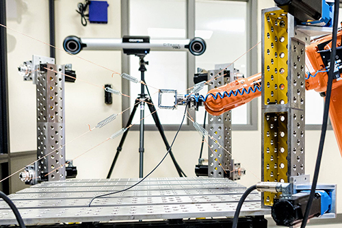 Laboratoire avec robot industriel et système de vision pour recherche en automatisation.
