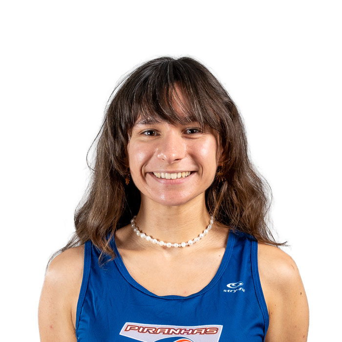 Étudiante souriante en tenue d'athlète avec logo Piranhas.