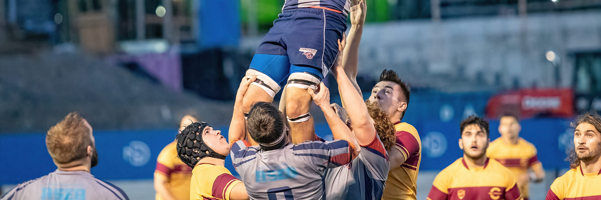 Étudiants en action lors d'un match de rugby, démontrant l'esprit d'équipe et l'excellence sportive.