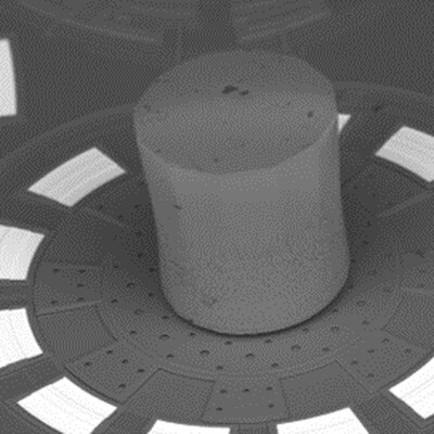A cylindrical object positioned on a circular base with multiple holes, showcasing advanced engineering design and precision technology.