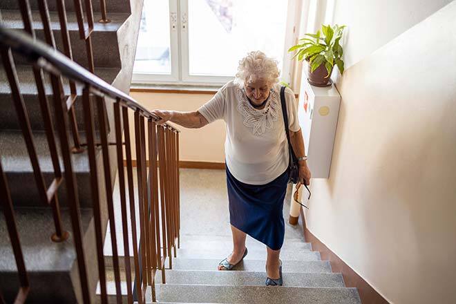 Elderly woman climbing stairs