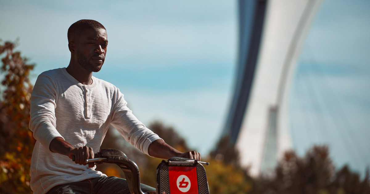 Étudiant en balade à vélo sur campus, automne.