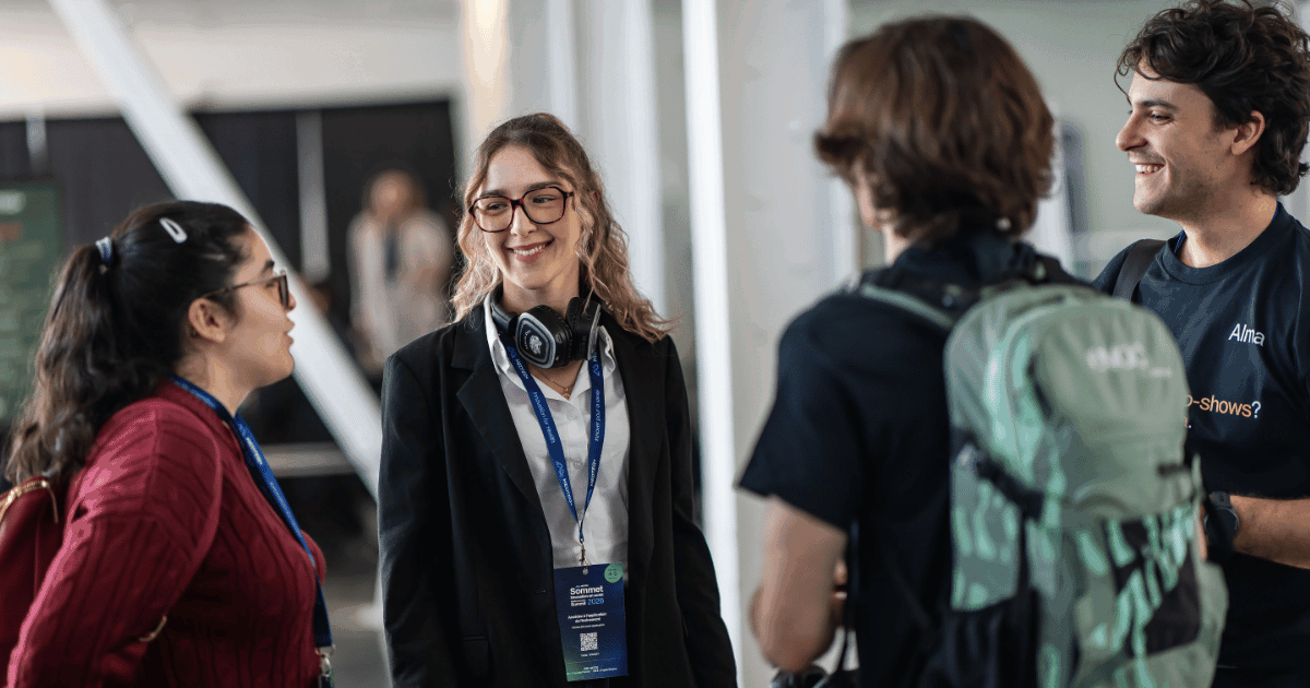 Un groupe d'étudiants échange des idées avec enthousiasme lors d'un événement, mettant en avant la collaboration et l'innovation.