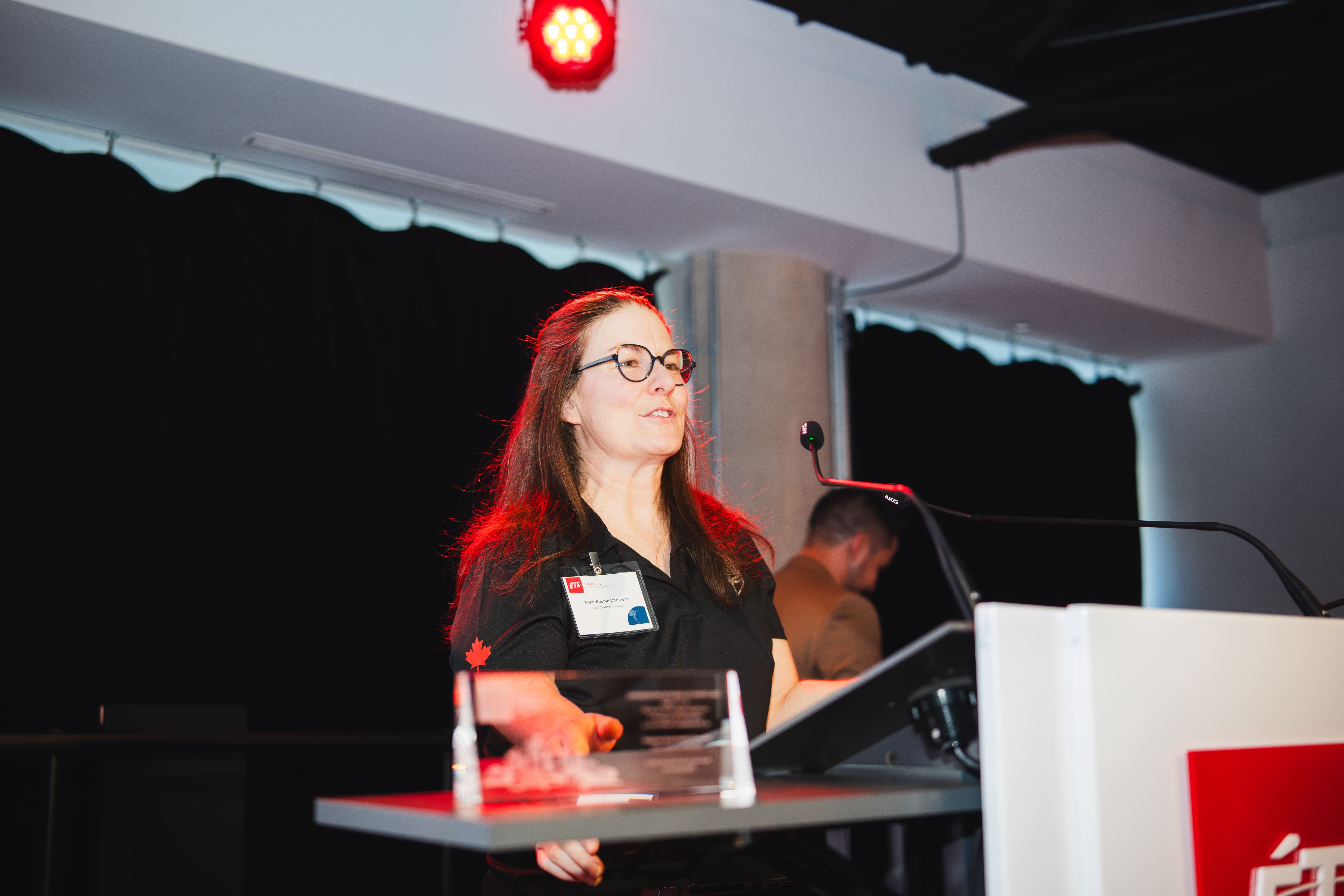 Une intervenante partage son expertise lors d'un événement universitaire, captivant l'audience avec une présentation engageante.