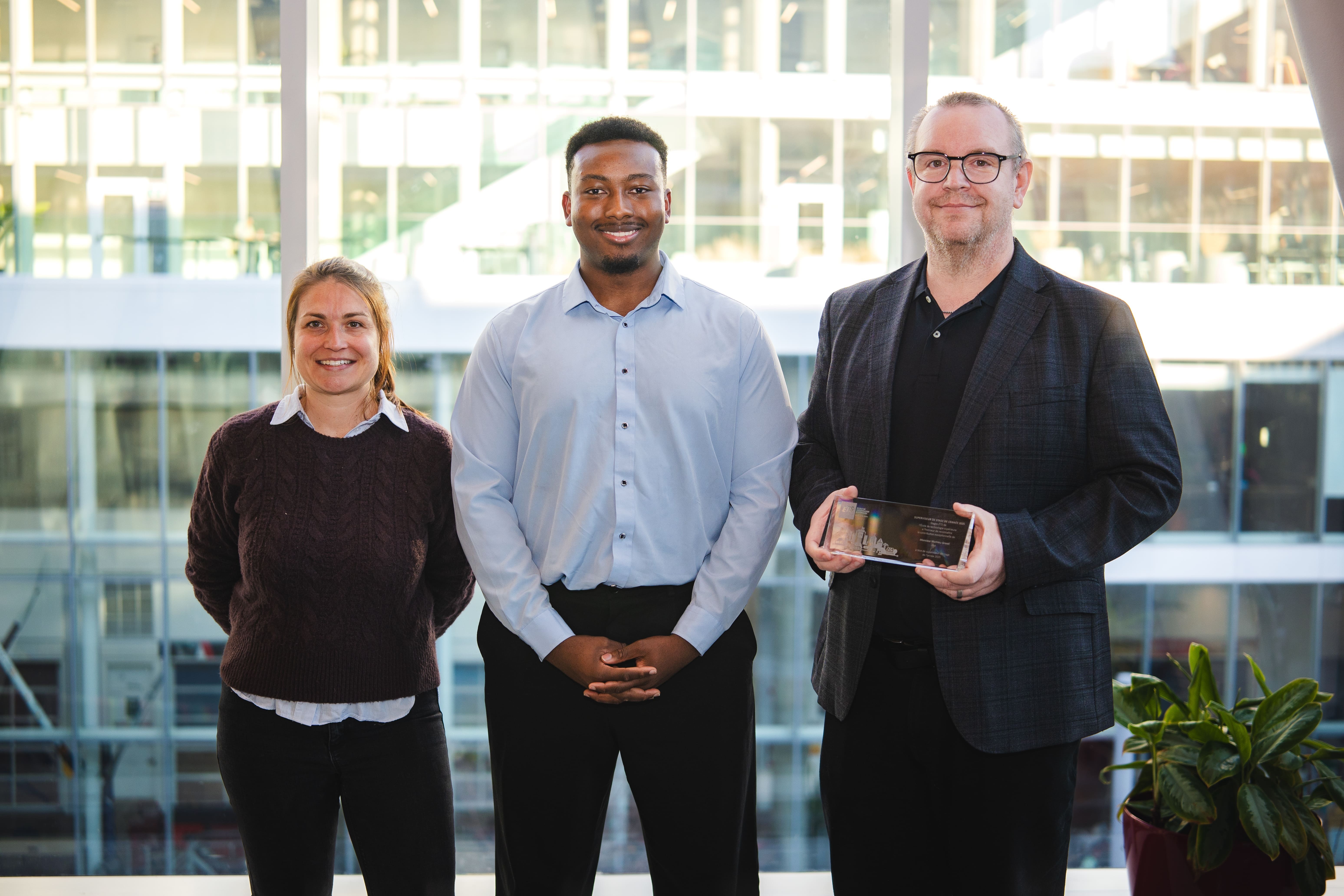 Trois personnes souriantes posent ensemble dans un cadre moderne, mettant en avant une réalisation honorable.
