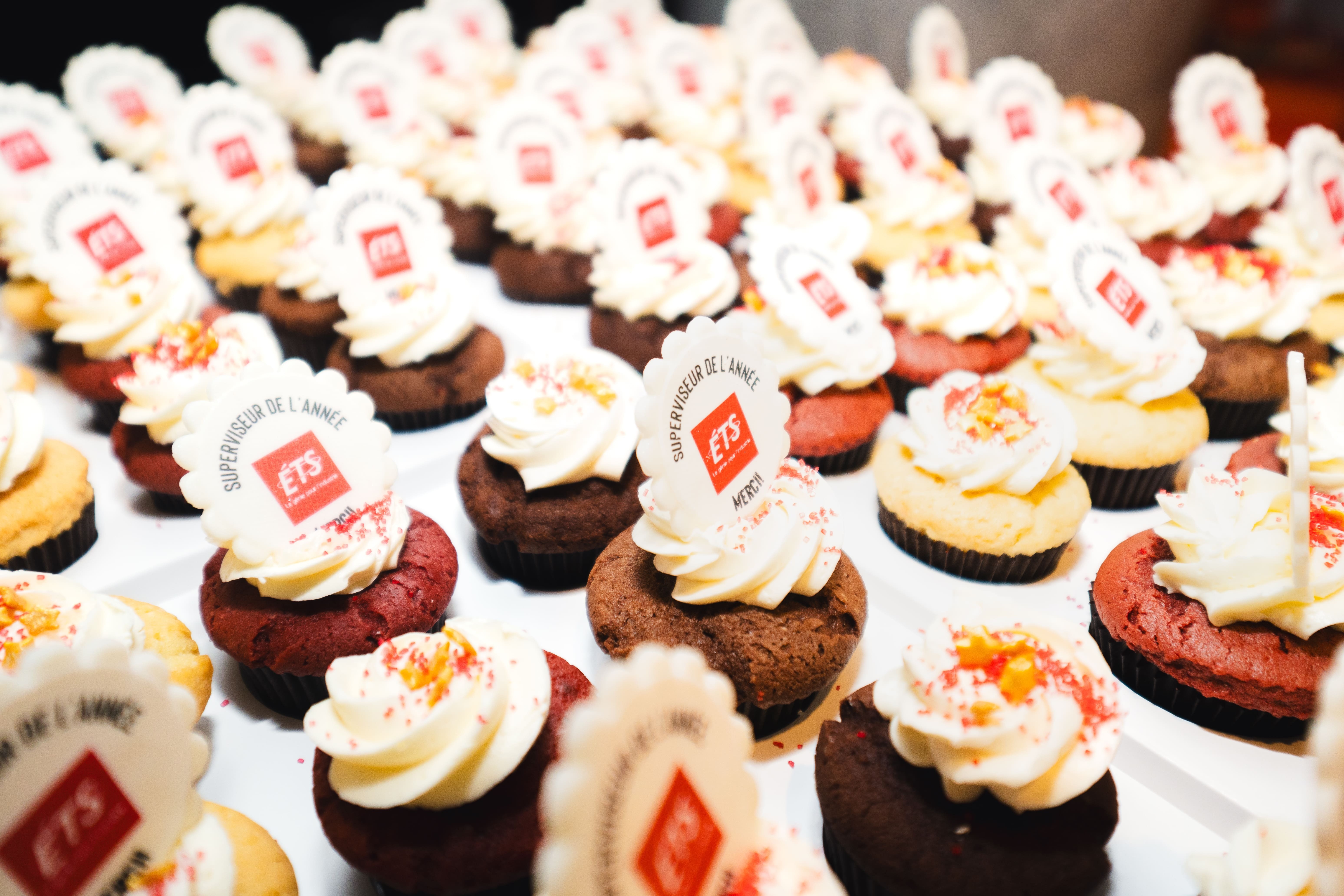 Une sélection de cupcakes décorés, célébrant le « Superviseur de l'année » à l'ETS, avec des saveurs variées et du glaçage.