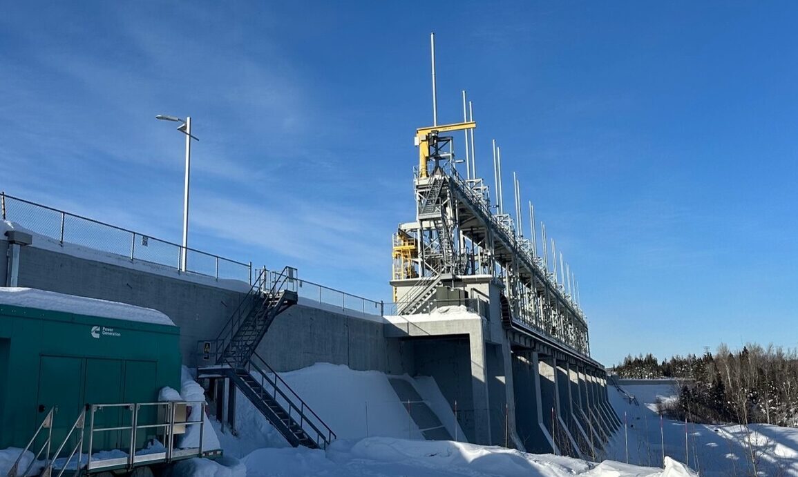 Installations de recherche en énergie, entourées de neige, avec équipements modernes et environnement technique sous un ciel bleu.