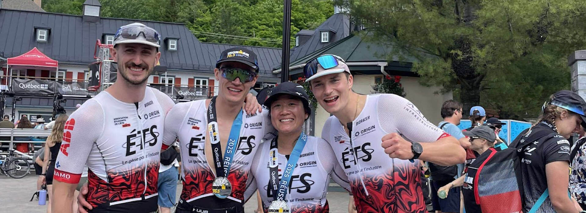 Trois étudiants et une étudiante posent joyeusement pour la caméra après une épreuve sportive, l'ambiance est dynamique et sportive.