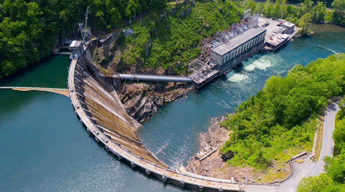 Centrale hydroélectrique avec barrage et végétation environnante.